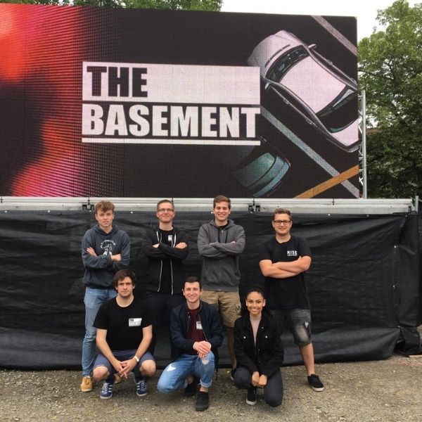Die Coverband Basement posiert vor einem Plakat