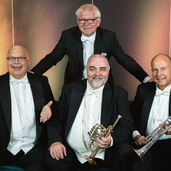 Die Blasmusikgruppe "Ensemble Tromba Festiva" posieren zu viert, teilweise mit ihren Blasinstrumenten für das Konzert am 09.02.2025 in Ramstein